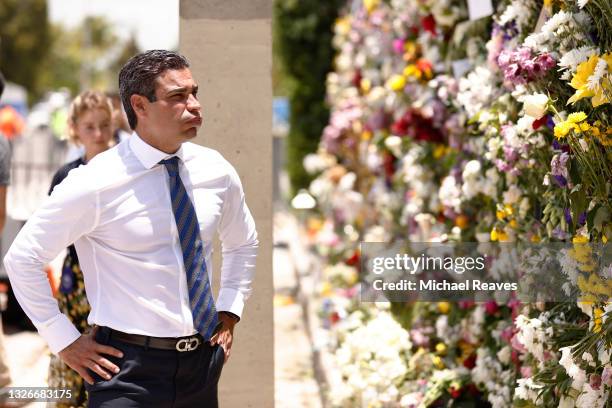 Miami Mayor Francis Suarez visits a memorial that has pictures of some of the missing from the partially collapsed 12-story Champlain Towers South...