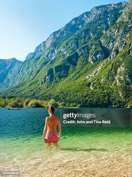 woman standing at lake - slovenia beach stock pictures, royalty-free photos & images