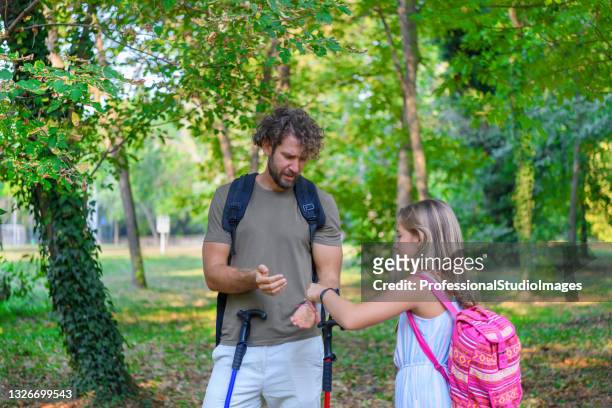 o homem está viajando na floresta com sua garotinha e enfrentando um mosquito. - tick bite - fotografias e filmes do acervo