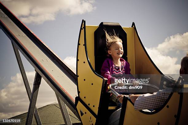 girl sitting on roller-coaster - parque de diversiones fotografías e imágenes de stock