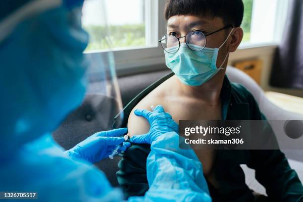 close up asian young adult  feeling relaxation and no concern with doctor vaccination covid-19(coronavirus) at vaccination center - drive through testing stock pictures, royalty-free photos & images