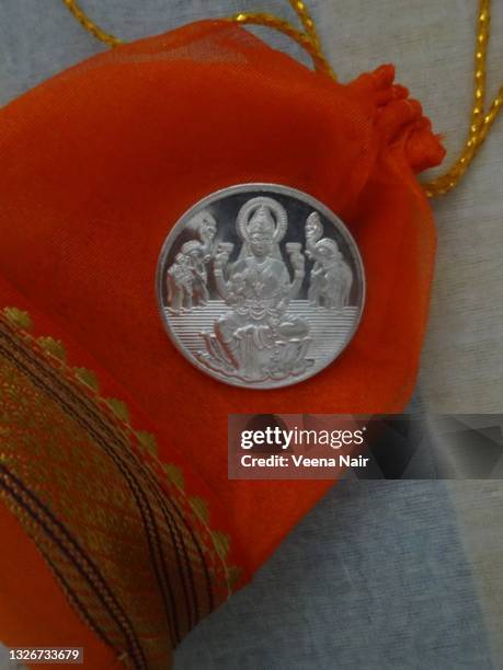 goddess lakshmi silver coin on an orange silk potli/ drawstring bag/india - laxmi stock pictures, royalty-free photos & images