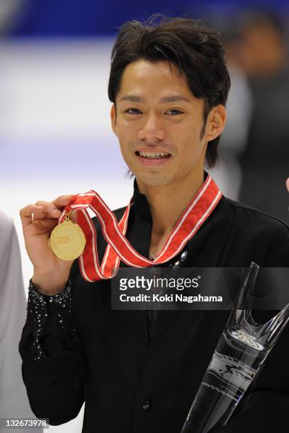 Daisuke Takahashi of Japan with a gold medal poses for photograghs in the men's singles during day three of the ISU Grand Prix of Figure Skating NHK...