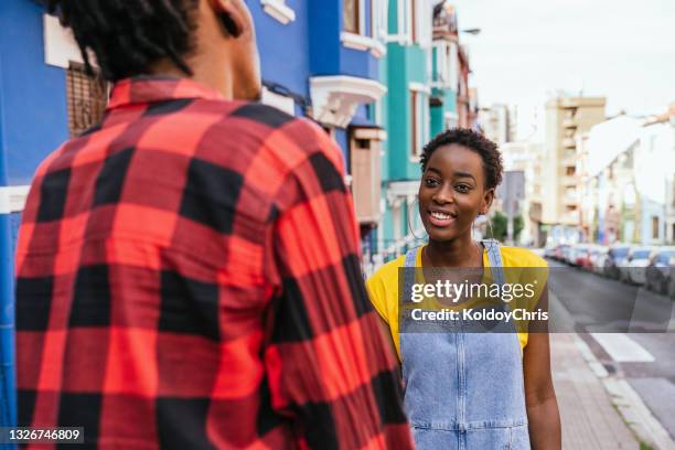 view over the shoulder of a man with a female friend talking normally - over the shoulder view stock-fotos und bilder