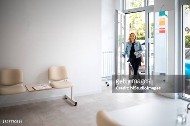 the pregnant woman enters the clinic - entering stock pictures, royalty-free photos & images