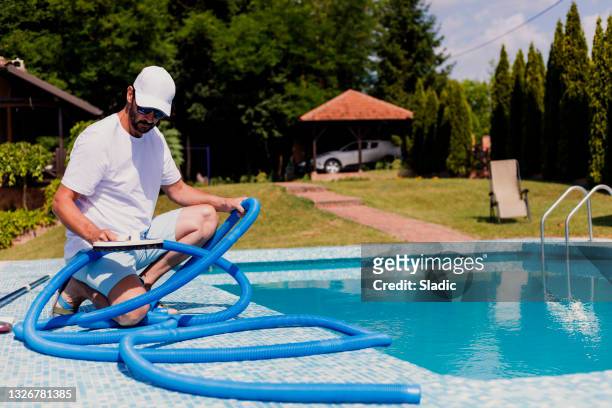 man cleaning the swimming pool - swimming pool cleaning stock pictures, royalty-free photos & images