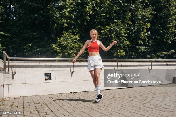 a young beautiful slender woman is dancing the melbourne shuffle dance on the streets of the city. - women in daisy dukes ストックフォトと画像