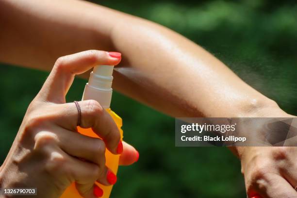 persona que rocía repelente de insectos mosquitos en el bosque, protección contra insectos - espray insecticida fotografías e imágenes de stock