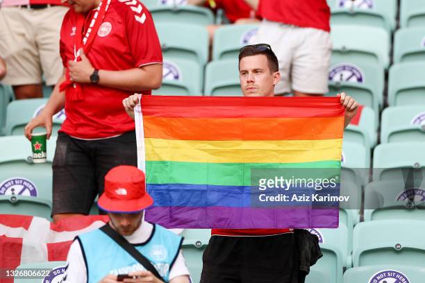 Denmark supporter holds a rainbow flag among national flags before the UEFA EURO 2020 quarter-final football match between Czech Republic v Denmark...