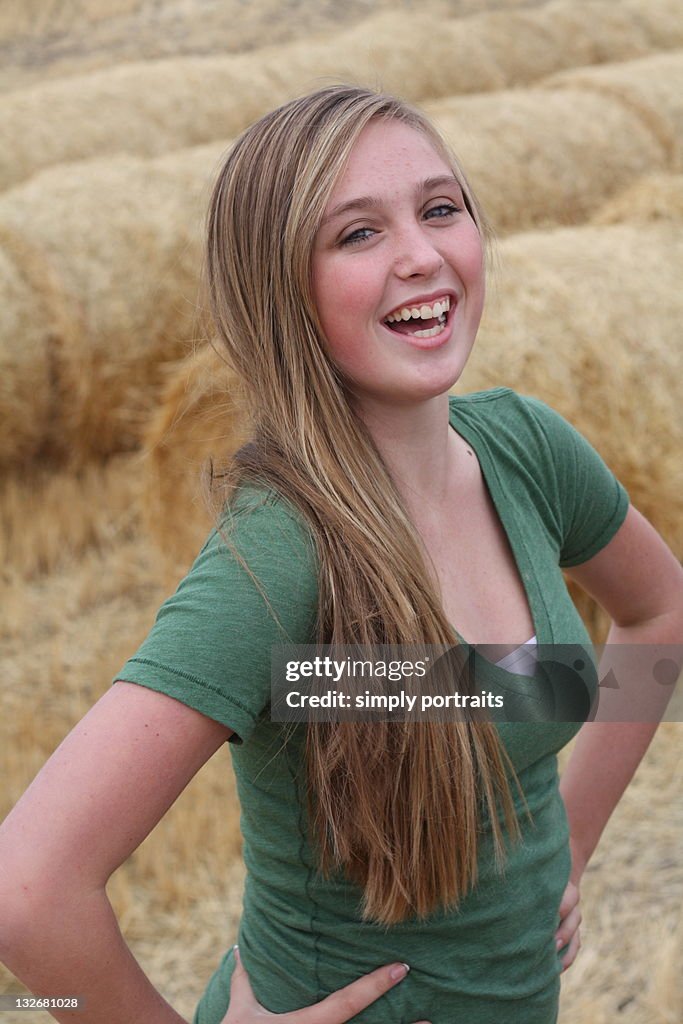 Portrait of girl beside hay bales