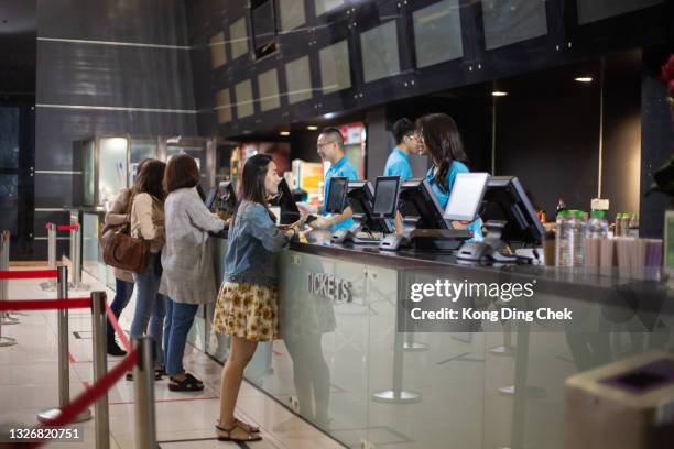 grupo de personas hacen cola y compran entradas en la sala de cine - ticket counter fotografías e imágenes de stock