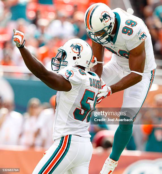Karlos Dansby is congratulated by Jason Taylor of the Miami Dolphins after he sacked Rex Grossman of the Washington Redskins on November 13, 2011 at...
