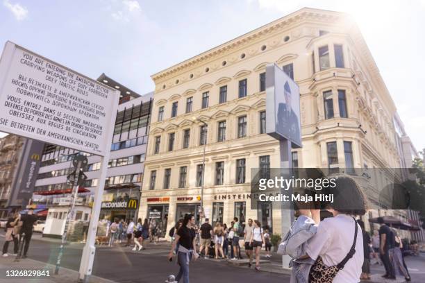 Tourist takes a photo at Checkpoint Charlie, the best-known Berlin Wall crossing point between East Berlin and West Berlin during the Cold War, on...