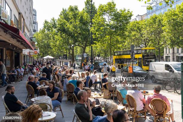 People sit at the restaurant near the popular shopping street Kurfürstendamm on July 03, 2021 in Berlin, Germany. Tourism is showing strong signs of...