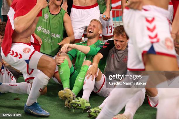Kasper Schmeichel and Mikkel Damsgaard of Denmark celebrate with teammates after victory in the UEFA Euro 2020 Championship Quarter-final match...