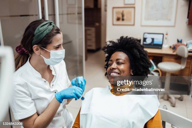 afro-amerikanerin zu besuch beim zahnarzt - sprechstundenhilfe stock-fotos und bilder