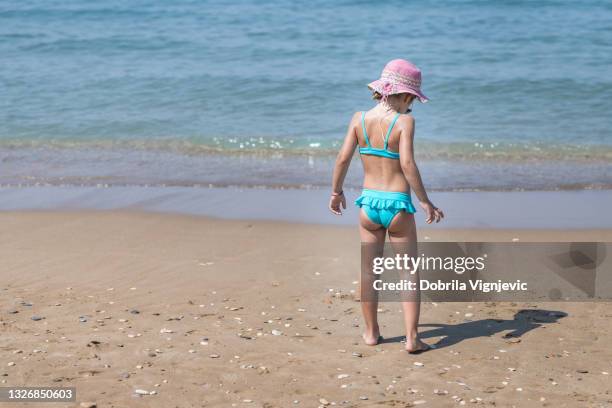 kleines kind am strand stehend - swimsuit stock-fotos und bilder