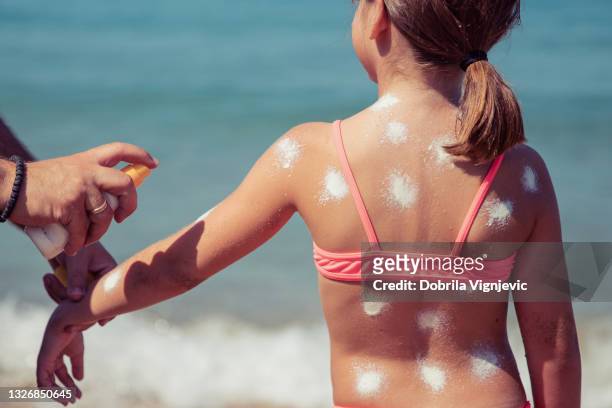 young child having sun protection on her body - applying sunblock stock pictures, royalty-free photos & images