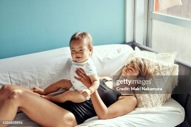 mom and baby are relaxing on the bed. - kids in undies stock pictures, royalty-free photos & images