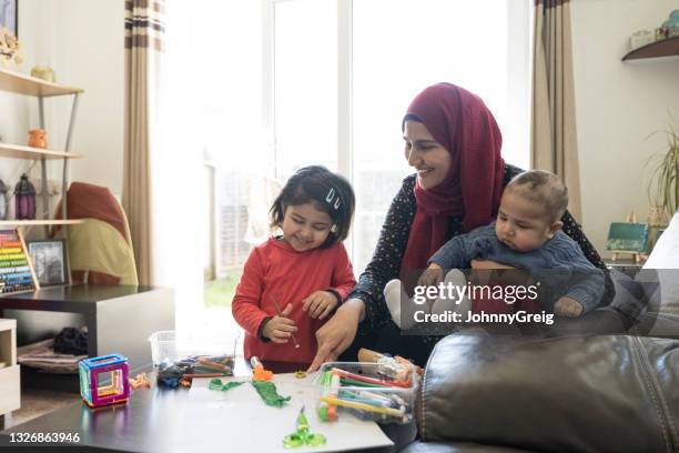 british asian woman with baby and daughter during craft time - male muslims uk stockfoto's en -beelden