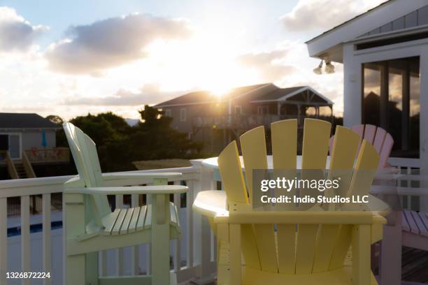 sun drenched deck with colorful chairs at beach house - retirement community building stock pictures, royalty-free photos & images