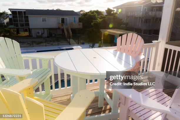 sun drenched deck with colorful chairs at beach house - sun deck stock pictures, royalty-free photos & images
