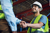 Shot of two builders shaking hands at a construction site