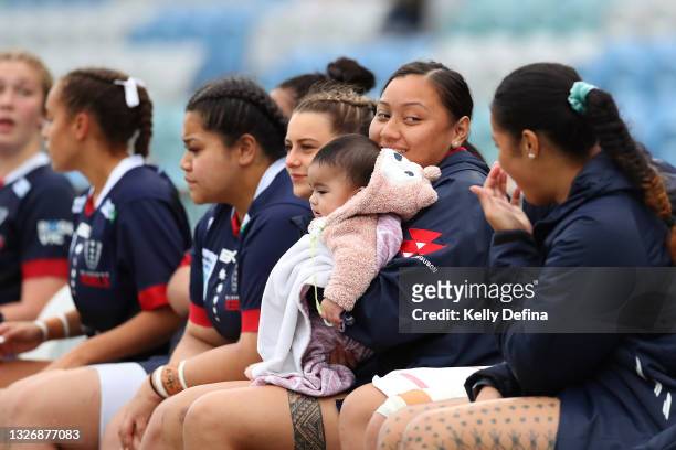 Rosalia Leumuava of the Rebels looks on while holding an assistant coaches baby during the Super W match between the Melbourne Rebels and the ACT...