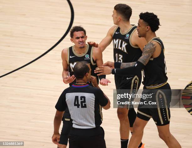 Trae Young of the Atlanta Hawks argues a technical foul with referee Eric Lewis during the second half in Game Six of the Eastern Conference Finals...