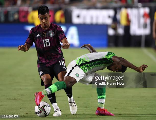 Anayo Iwuala of Nigeria tries to gain control of the ball in front of Efrain Alvarez of Mexico in a 4-0 Mexico win during an international friendly...