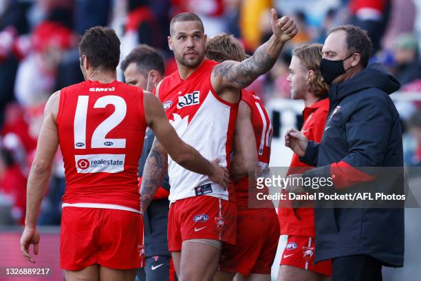 Lance Franklin of the Swans gestures to a friend in the crowd as Josh P. Kennedy of the Swans and Swans head coach John Longmire celebrate victory...