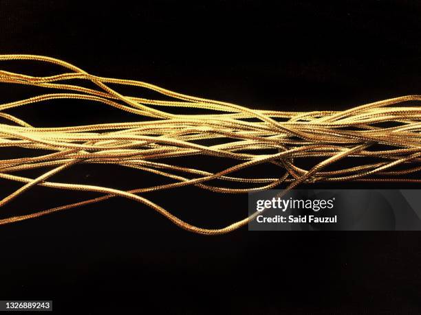 gold rope on black background - lunghezza foto e immagini stock