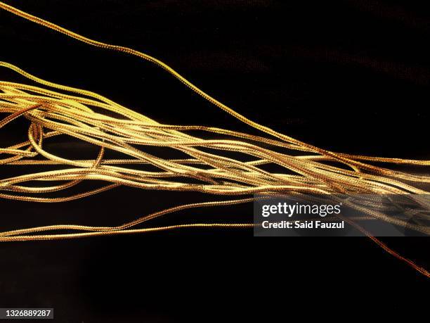 gold rope on black background - rope length stock pictures, royalty-free photos & images