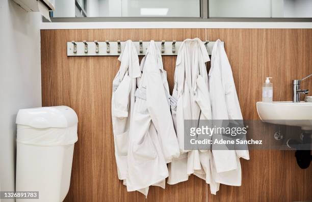 scatto di un bagno vuoto in un laboratorio con cappotti da laboratorio appesi - abbigliamento da lavoro foto e immagini stock