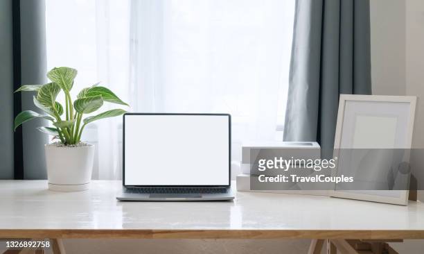 workplace with laptop on table at home. laptop with blank screen on white table. home interior or office background - scrivania foto e immagini stock