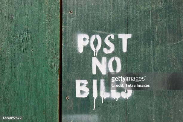 post no bills on green wooden fence - bill posting stock pictures, royalty-free photos & images