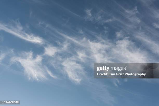 wispy white clouds in a blue sky - stratus stock pictures, royalty-free photos & images