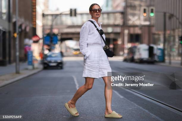 Anna Winter wearing black Bally bag, olive Adidas Yeezy sandals, Arket linen pants, Uniqlo linen top and Vehla shades on June 27, 2021 in Berlin,...