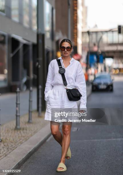 Anna Winter wearing black Bally bag, olive Adidas Yeezy sandals, Arket linen pants, Uniqlo linen top and Vehla shades on June 27, 2021 in Berlin,...