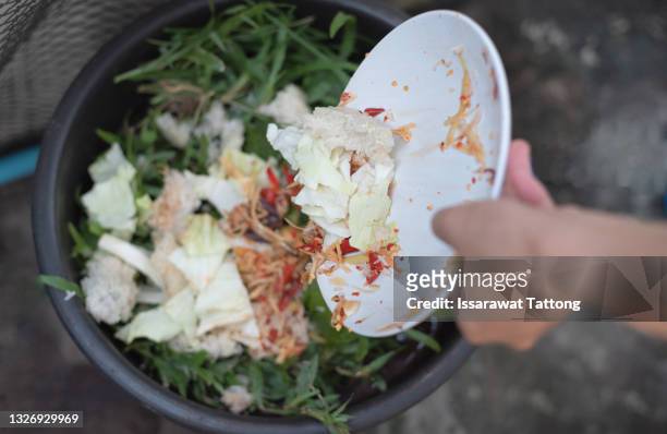 vegetable peels are thrown from cutting board into an iron bowl with organic food waste. food leftovers ready to compost. environmentally responsible behavior, ecological, recycling waste concept. - lebensmittel müll stock-fotos und bilder