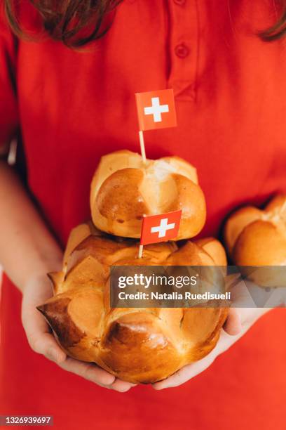 close up of young girl hands holding traditional swiss bread to celebrate swiss national holiday. - august stock-fotos und bilder