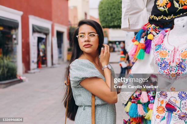young woman shopping touching her hair - ville de queretaro photos et images de collection