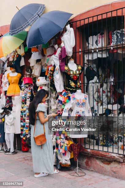 rear view of woman standing in front of a souvenir shop - mexican street market stock pictures, royalty-free photos & images