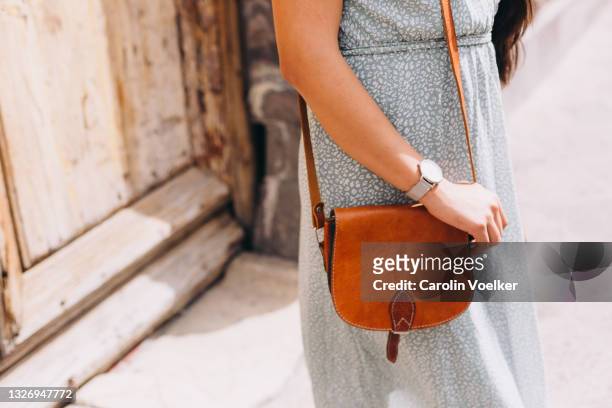 close up of woman gripping a small leather purse - handtasche stock-fotos und bilder