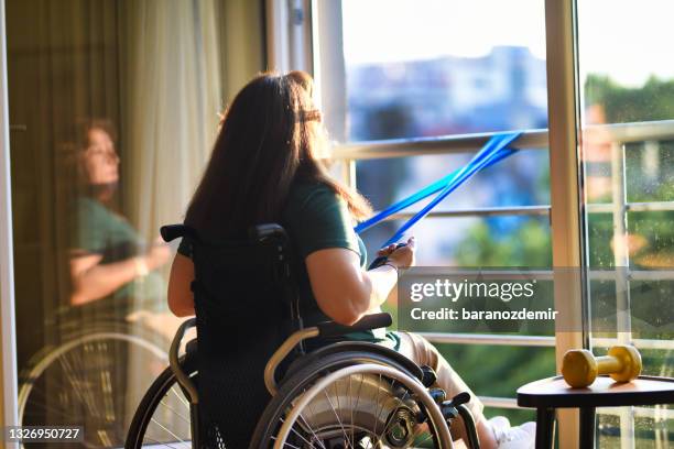 woman in wheelchair exercising with resistance band - förlamning bildbanksfoton och bilder