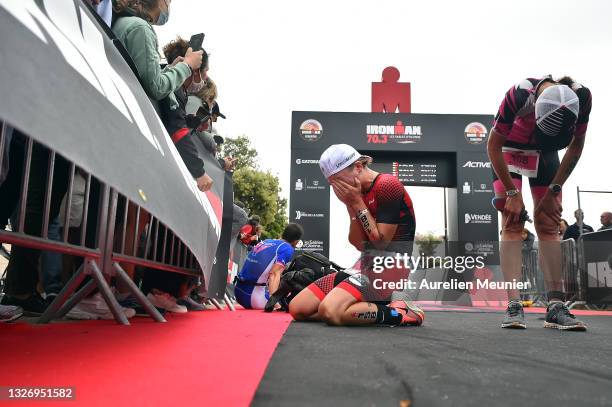 Exhausted athletes react at the finish line during the IRONMAN 70.3 on July 04, 2021 in Les Sables d'Olonne, Unspecified.