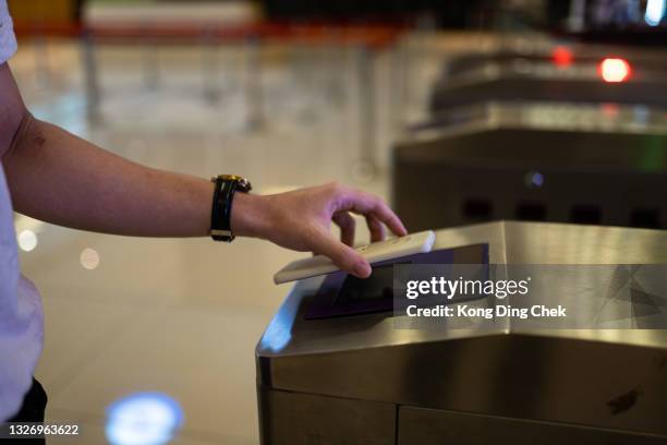 close up asian chinese man hand enter to movie theater using smart phone mobile app barcode scanning. - entering turnstile stock pictures, royalty-free photos & images