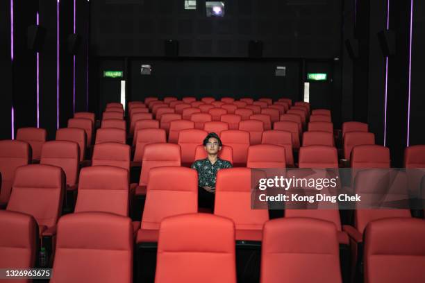 asian chinese teenager alone in cinema watching movie - theater seat stock pictures, royalty-free photos & images