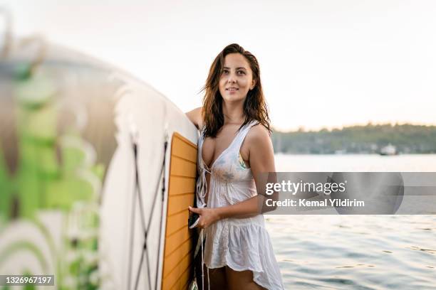 young woman coming from sup - practioners enjoy serenity of paddleboard yoga stockfoto's en -beelden