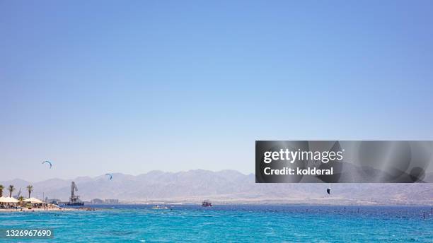 red sea with distant view of israeli eilat and jordanian aqaba - aqaba stock pictures, royalty-free photos & images